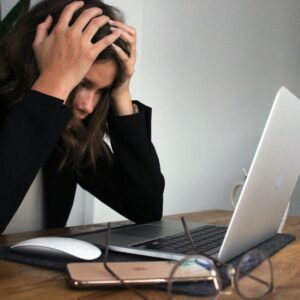 a woman sitting in front of a laptop computer